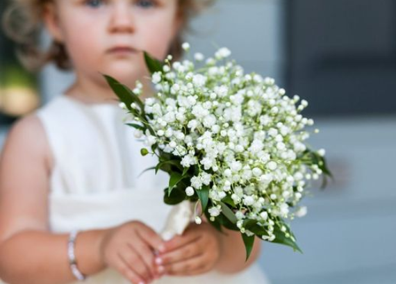 Lovely flower girl holding a bunch of babysbreath