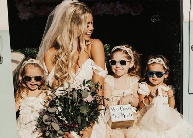 Pretty bride with her flower girls who are wearing sunglasses